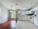 Bright kitchen with white cabinets, stainless steel appliances, and adjoining dining area with hardwood floors at 350 Scrub Jay Way, Davenport, FL 33896