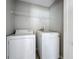 This laundry room has a washer, dryer, and wire shelf for storage at 350 Scrub Jay Way, Davenport, FL 33896