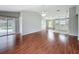 Bright, open-concept living room with wood floors, leading to a kitchen and patio doors to backyard pool at 350 Scrub Jay Way, Davenport, FL 33896