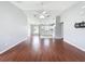 Open floor plan with wood floors, vaulted ceilings, and kitchen featuring white appliances and tile flooring at 350 Scrub Jay Way, Davenport, FL 33896