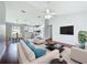 Staged living room with hardwood floors, kitchen, dining area and a flat screen television at 350 Scrub Jay Way, Davenport, FL 33896