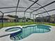 Inviting screened-in pool and spa with blue tile accents, perfect for relaxation and entertaining at 350 Scrub Jay Way, Davenport, FL 33896
