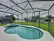Backyard screened-in pool and spa with lush green lawn, offering a private and tranquil retreat at 350 Scrub Jay Way, Davenport, FL 33896