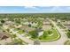 Aerial view of a residential area with well-maintained homes, green lawns, and a small lake at 3859 Spirited Cir, St Cloud, FL 34772