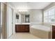 Bathroom includes a soaking tub and a dark wood vanity at 3859 Spirited Cir, St Cloud, FL 34772
