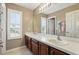 Bathroom with double sinks, a large mirror, and a window that provides natural light at 3859 Spirited Cir, St Cloud, FL 34772