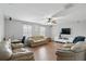Spacious living room with hardwood floors, comfortable seating, and a modern entertainment center at 3859 Spirited Cir, St Cloud, FL 34772