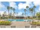 Community pool area with palm trees, lounge chairs, and a covered seating area at 3859 Spirited Cir, St Cloud, FL 34772