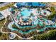 Aerial view of a community pool and lazy river with colorful umbrellas and lush landscaping at 3878 Lana Ave, Davenport, FL 33897