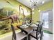 Whimsical dining area with a modern chandelier and vibrant dinosaur-themed wallpaper at 3878 Lana Ave, Davenport, FL 33897