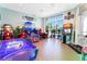 Bright game room featuring an array of arcade games, air hockey, and a large window with a view at 3878 Lana Ave, Davenport, FL 33897