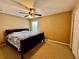 Cozy bedroom features a ceiling fan, plush carpet and a window for natural light at 4368 Fox Glen Loop, Kissimmee, FL 34746