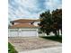 Charming two-story home with a three car garage and a brick driveway with a beautiful lawn and landscaping at 4368 Fox Glen Loop, Kissimmee, FL 34746
