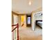 Upstairs hallway with neutral colored carpet and walls leads to a bedroom and bathroom at 4368 Fox Glen Loop, Kissimmee, FL 34746