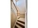 Staircase featuring carpeted steps, a wooden handrail, and white painted trim creating a classic, clean look at 4368 Fox Glen Loop, Kissimmee, FL 34746
