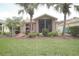 Lush backyard featuring a screened lanai, mature palm trees, and well-maintained landscaping at 516 Millifiora Ln, Kissimmee, FL 34759
