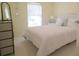 This bedroom features neutral walls, a queen bed with white linens, and natural light from a window with blinds at 516 Millifiora Ln, Kissimmee, FL 34759