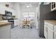 Bright kitchen featuring white cabinets, stainless steel appliances, and a cozy breakfast nook at 516 Millifiora Ln, Kissimmee, FL 34759