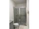 Bathroom featuring glass shower, grey tile, toilet and modern fixtures at 522 Feltrim Manor Rd, Haines City, FL 33844