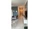 Hallway with gray chair, tiled floor, and decorative console table with large-screen television at 522 Feltrim Manor Rd, Haines City, FL 33844
