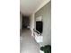 Hallway with tile floors, decorative wall, and console table with a large screen television at 522 Feltrim Manor Rd, Haines City, FL 33844