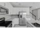 Modern kitchen with white cabinets, stainless steel appliances, granite countertops, and tile flooring at 540 Summit River Dr, Apopka, FL 32712