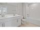 Bright bathroom with a double sink vanity, white cabinets, and a bathtub with a shower at 555 Summit River Dr, Apopka, FL 32712