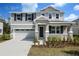 Charming two-story home with a two-car garage, gray siding and lovely landscaping at 555 Summit River Dr, Apopka, FL 32712