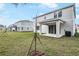 Backyard view of a two-story home with a covered patio and freshly planted tree at 565 Summit River Dr, Apopka, FL 32712