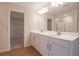Bathroom featuring double sink vanity, wood-look flooring, and view of a walk-in closet at 565 Summit River Dr, Apopka, FL 32712