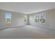 Bright, carpeted bedroom with three windows providing ample natural light and outdoor views at 565 Summit River Dr, Apopka, FL 32712