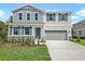 Charming two-story home with light blue and white siding, shutters, stone accents, and a well-manicured lawn at 565 Summit River Dr, Apopka, FL 32712