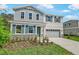 Lovely two-story home features light blue siding, shuttered windows, stone accents, and a large driveway at 565 Summit River Dr, Apopka, FL 32712
