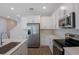Beautiful kitchen with white cabinets, quartz countertops, stainless steel appliances, and wood-look tile flooring at 565 Summit River Dr, Apopka, FL 32712