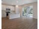 Open-concept kitchen with white cabinets, a peninsula island, and sliding glass doors to the backyard at 565 Summit River Dr, Apopka, FL 32712