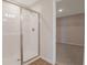 Walk-in shower featuring white tile, glass doors, and view into an adjacent walk-in closet at 565 Summit River Dr, Apopka, FL 32712