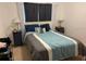 Comfortable bedroom showcasing a blue and gray comforter and soft lighting at 5930 Tivoli Gardens Blvd, Orlando, FL 32829