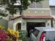 Charming two-story townhome with a red tile roof and an attached one-car garage at 5930 Tivoli Gardens Blvd, Orlando, FL 32829