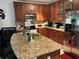 Modern kitchen featuring cherry cabinets, granite countertops, and stainless steel appliances at 5930 Tivoli Gardens Blvd, Orlando, FL 32829