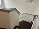 Staircase with wood treads, gray railing, and white walls leading upstairs at 5930 Tivoli Gardens Blvd, Orlando, FL 32829
