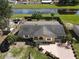 Aerial of landscaped home with driveway, manicured yard, fencing, and canal in background at 624 Royal Palm Dr, Kissimmee, FL 34743