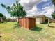 Spacious backyard featuring a storage shed, mature trees, and well-kept lawn at 624 Royal Palm Dr, Kissimmee, FL 34743