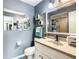Bathroom with a neutral palette, featuring a sink with a white cabinet and a framed mirror at 624 Royal Palm Dr, Kissimmee, FL 34743