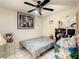 Modest bedroom with white tile flooring, ceiling fan, and essential furnishings for a comfortable living space at 624 Royal Palm Dr, Kissimmee, FL 34743