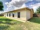 Rear exterior of the home with well-maintained siding, windows, and green lawn at 624 Royal Palm Dr, Kissimmee, FL 34743
