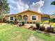 Inviting single-story home featuring a well-manicured lawn and vibrant landscaping at 624 Royal Palm Dr, Kissimmee, FL 34743