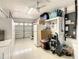 Organized garage with storage cabinets, refrigerator, and a clean, white floor at 624 Royal Palm Dr, Kissimmee, FL 34743