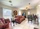 Inviting living area with red patterned sofa, tile flooring, ceiling fan, and access to the backyard, perfect for relaxing at 624 Royal Palm Dr, Kissimmee, FL 34743