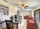 Spacious living room with dining area, featuring tile flooring, ceiling fan, and ample natural light from the windows at 624 Royal Palm Dr, Kissimmee, FL 34743