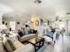 Open-concept living room flowing into a dining area, hardwood floors, and white walls at 624 Royal Palm Dr, Kissimmee, FL 34743